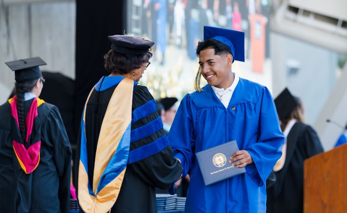 A Preuss student shaking hands at graduation